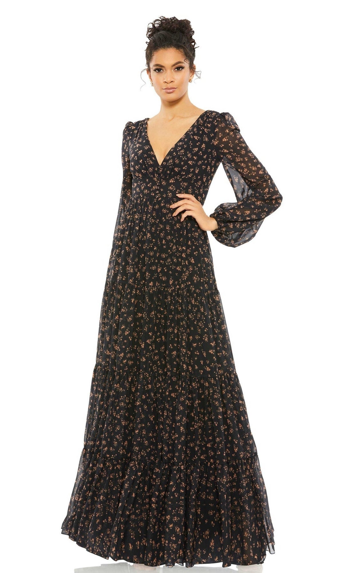 A person wearing the Long Formal Dress 55431 by Mac Duggal, featuring a floor-length v-neck design with a floral print and sheer long sleeves, stands against a white background.